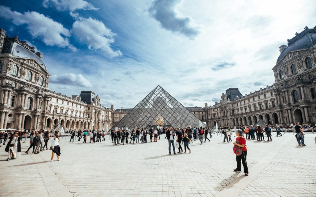 people walking in front of louvre museum