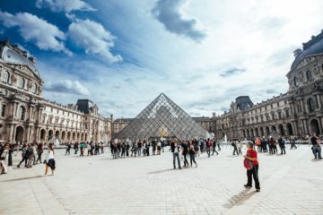 people walking in front of louvre museum